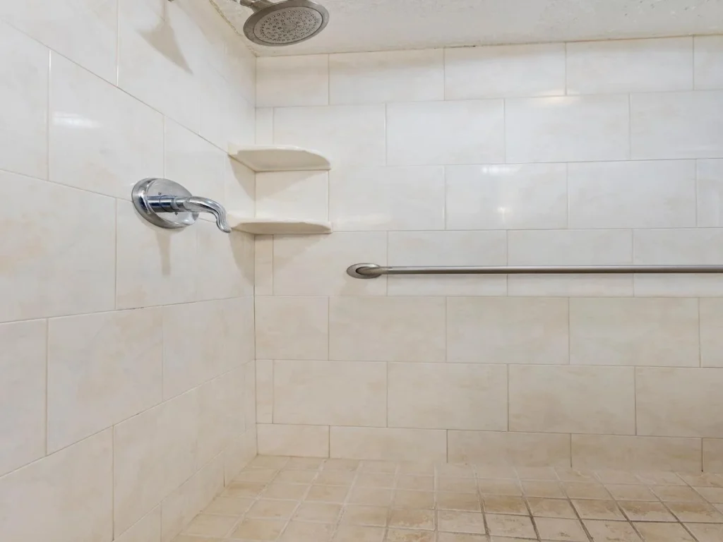 Spacious walk-in shower with modern fixtures and built-in shelves
