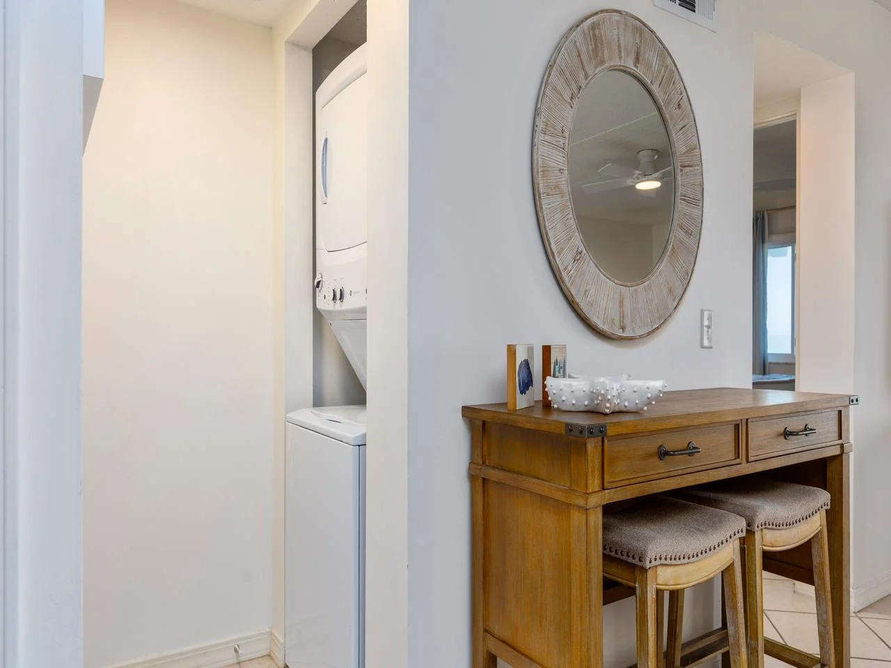 Cozy dining nook with stylish storage and stacked laundry around the corner!