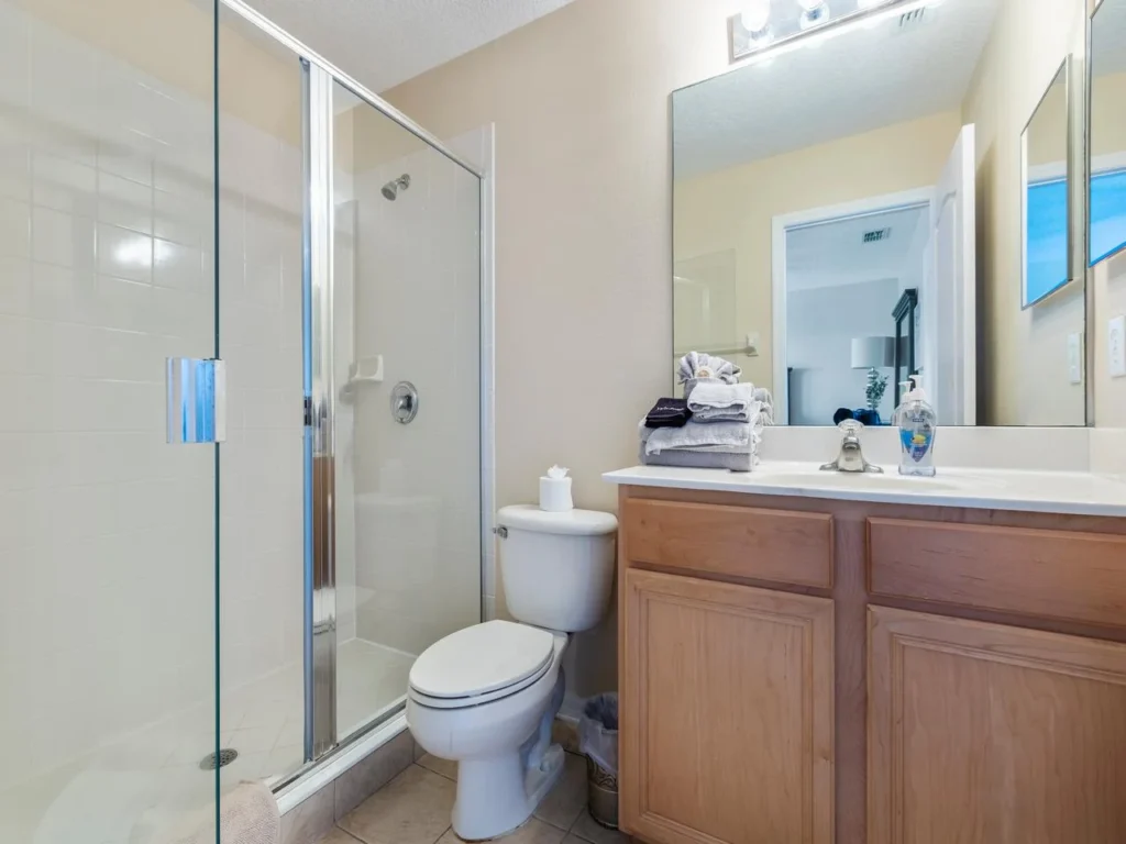 Bright, clean guest bathroom with modern glass shower and ample storage!
