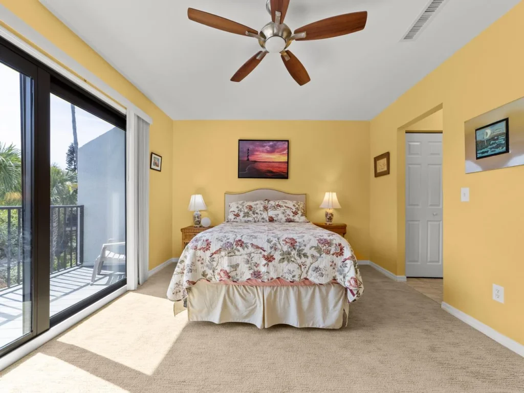 Sunlit bedroom with private balcony and cozy ambiance