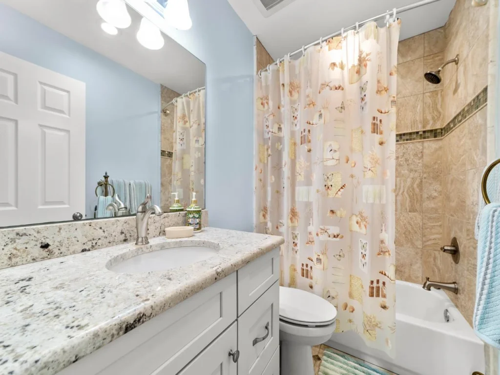 Bright and airy guest bathroom with granite countertop and tub/shower combo!