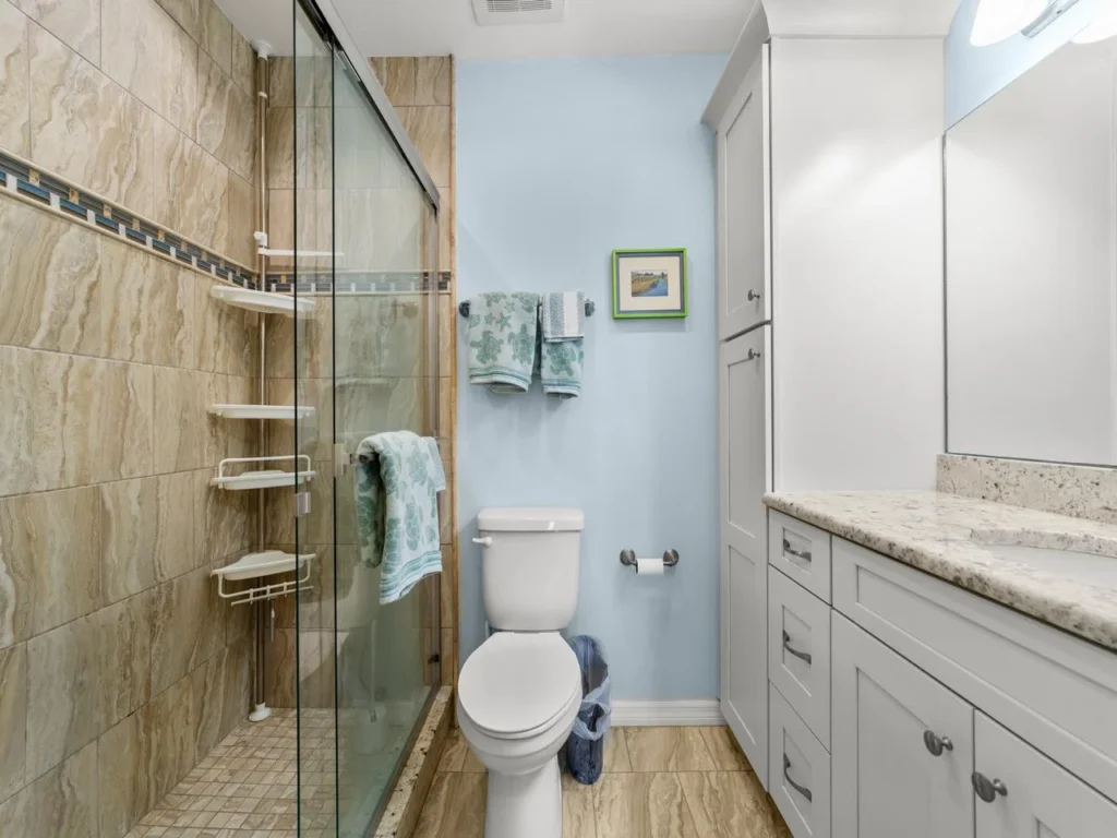 Spa-inspired primary bathroom with glass shower and granite countertop!