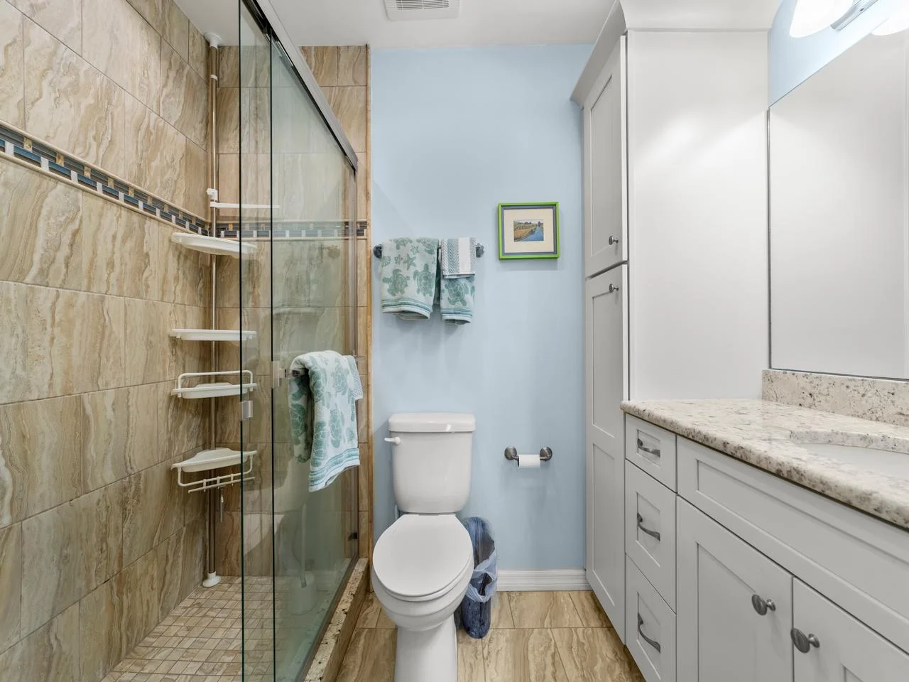 Spa-inspired primary bathroom with glass shower and granite countertop!
