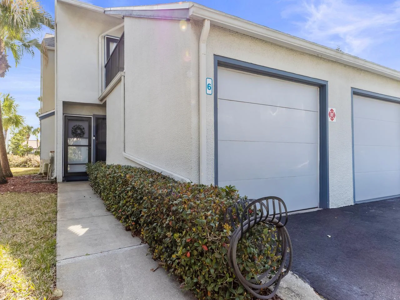 Private end unit entrance with convenient garage access and lush greenery!