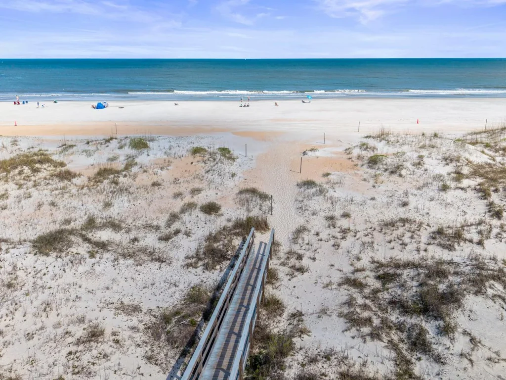 Private boardwalk leading to serene sandy beach and ocean views