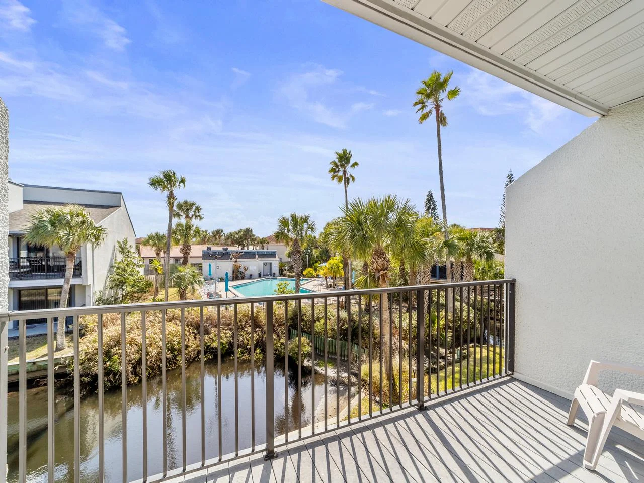 Serene primary bedroom balcony retreat overlooking tranquil waters and palm trees