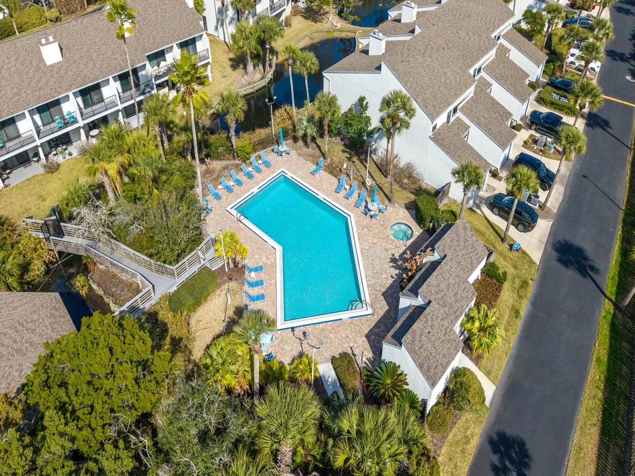 Resort-style pool surrounded by charming townhomes and lush greenery