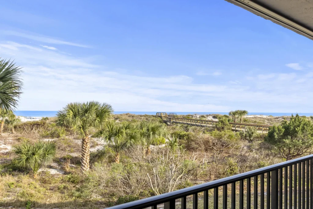 Ocean-view balcony overlooking lush coastal greenery and blue skies