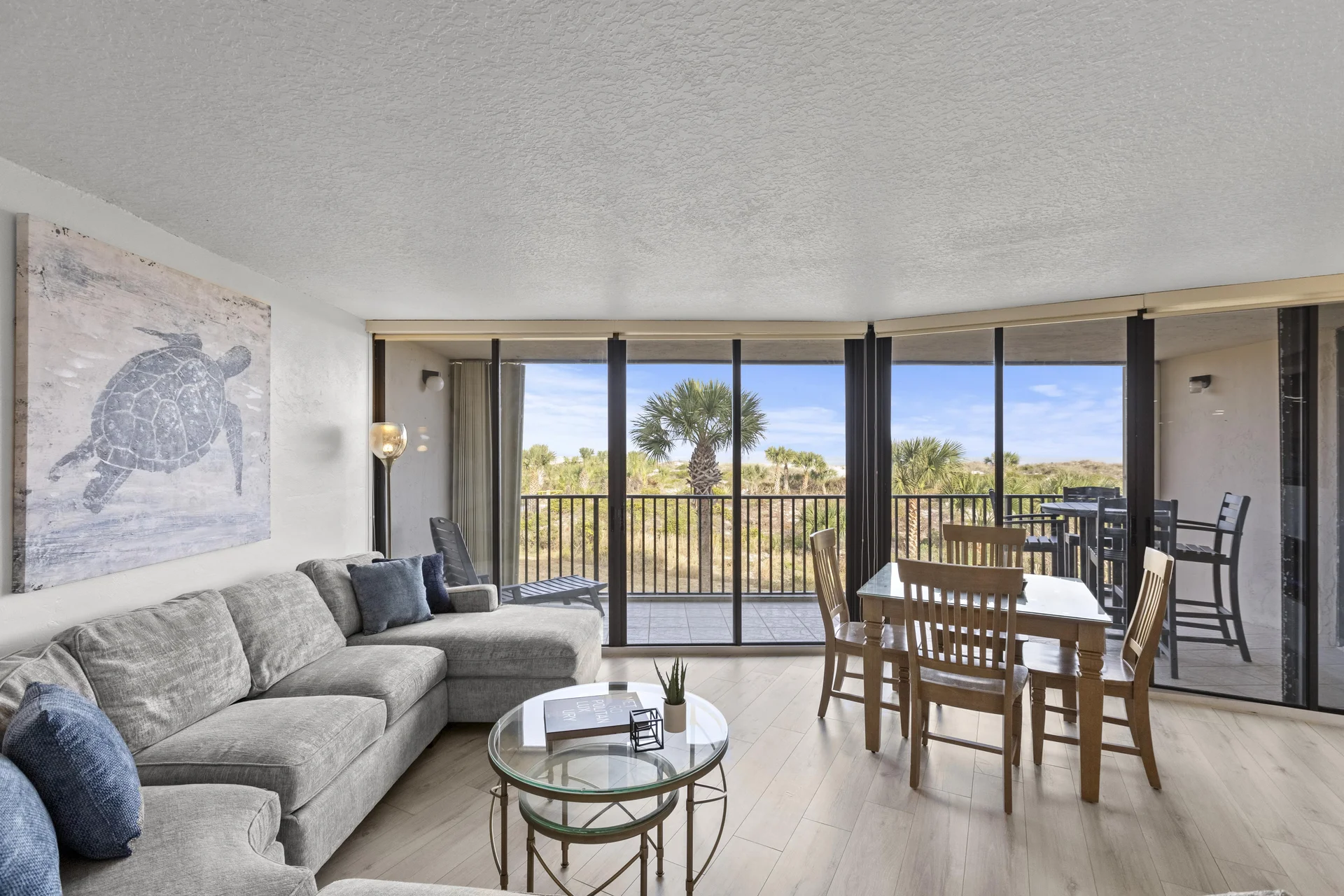 Sunlit living and dining area with panoramic ocean views