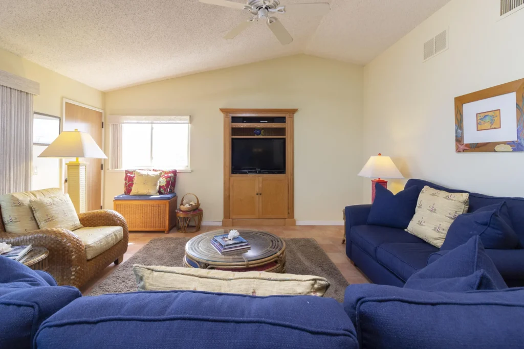Wall-mounted wooden entertainment center with flat-screen TV framed by pastel yellow walls and a vaulted ceiling.