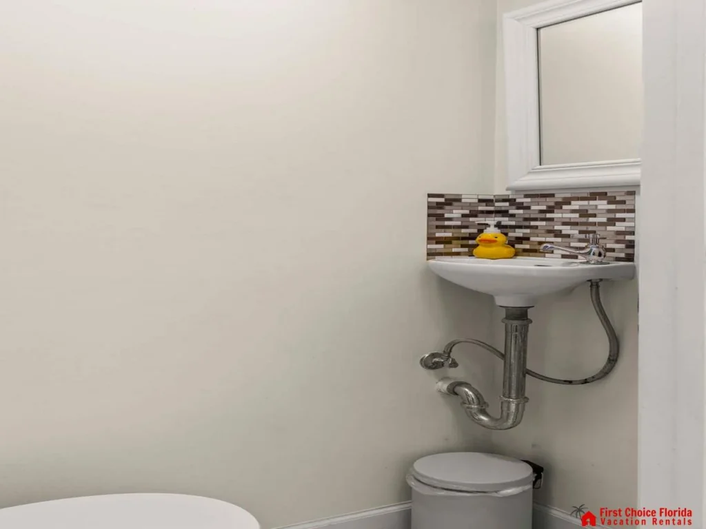 Compact powder room with modern stone-tiled sink backsplash