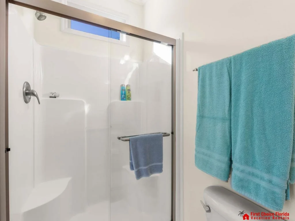 Bright, modern bathroom with spacious glass shower and fresh towels