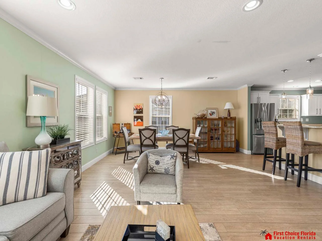 Sunlit dining and living area with cozy seating and open kitchen
