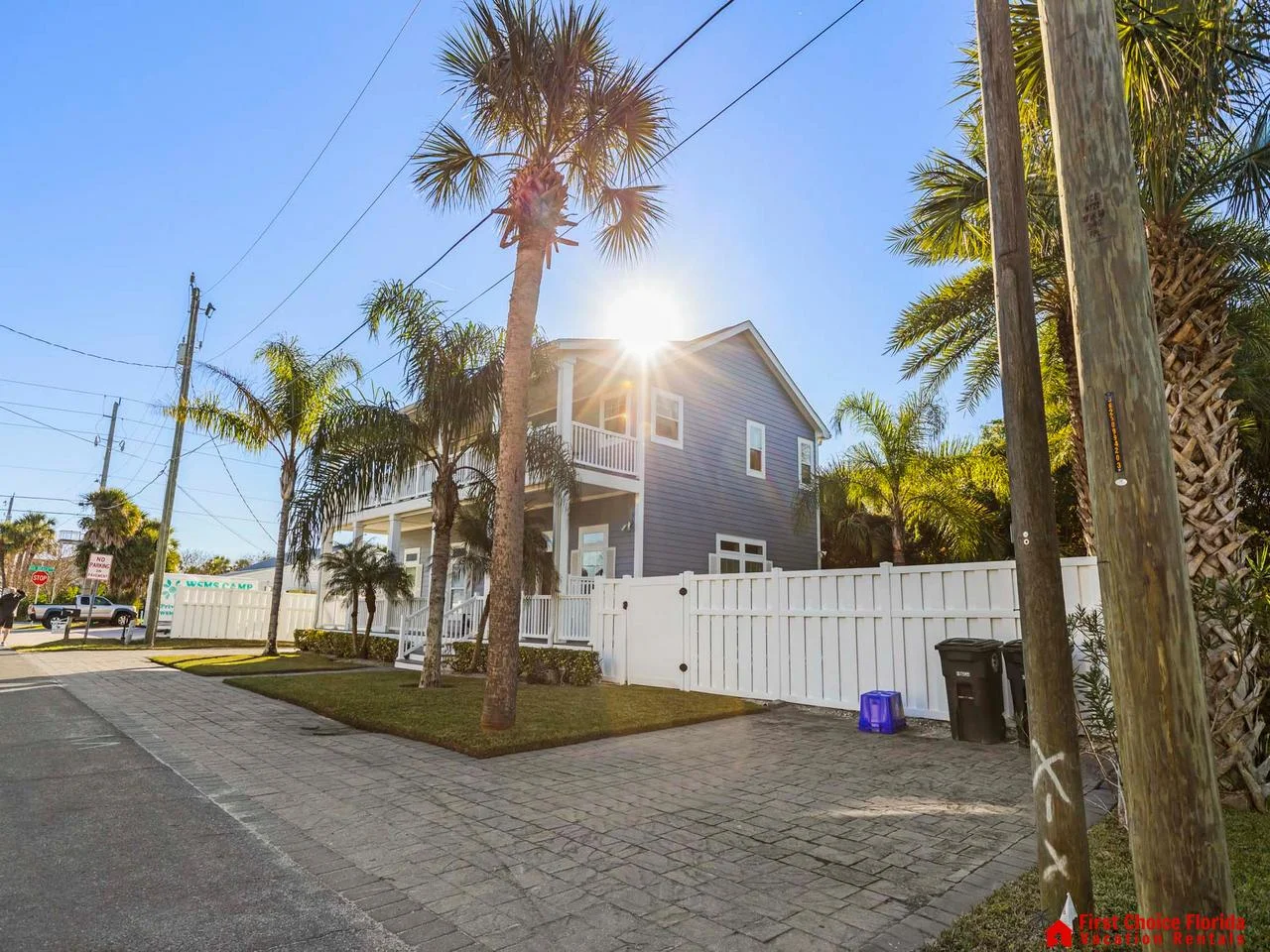 Sunny street view with charming coastal cottage and palm trees