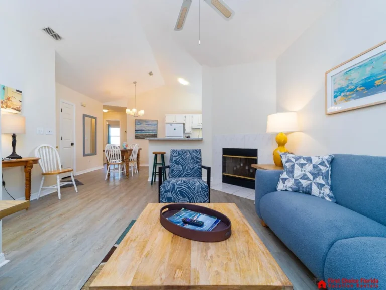 Bright open living room with decorative fireplace and modern kitchen