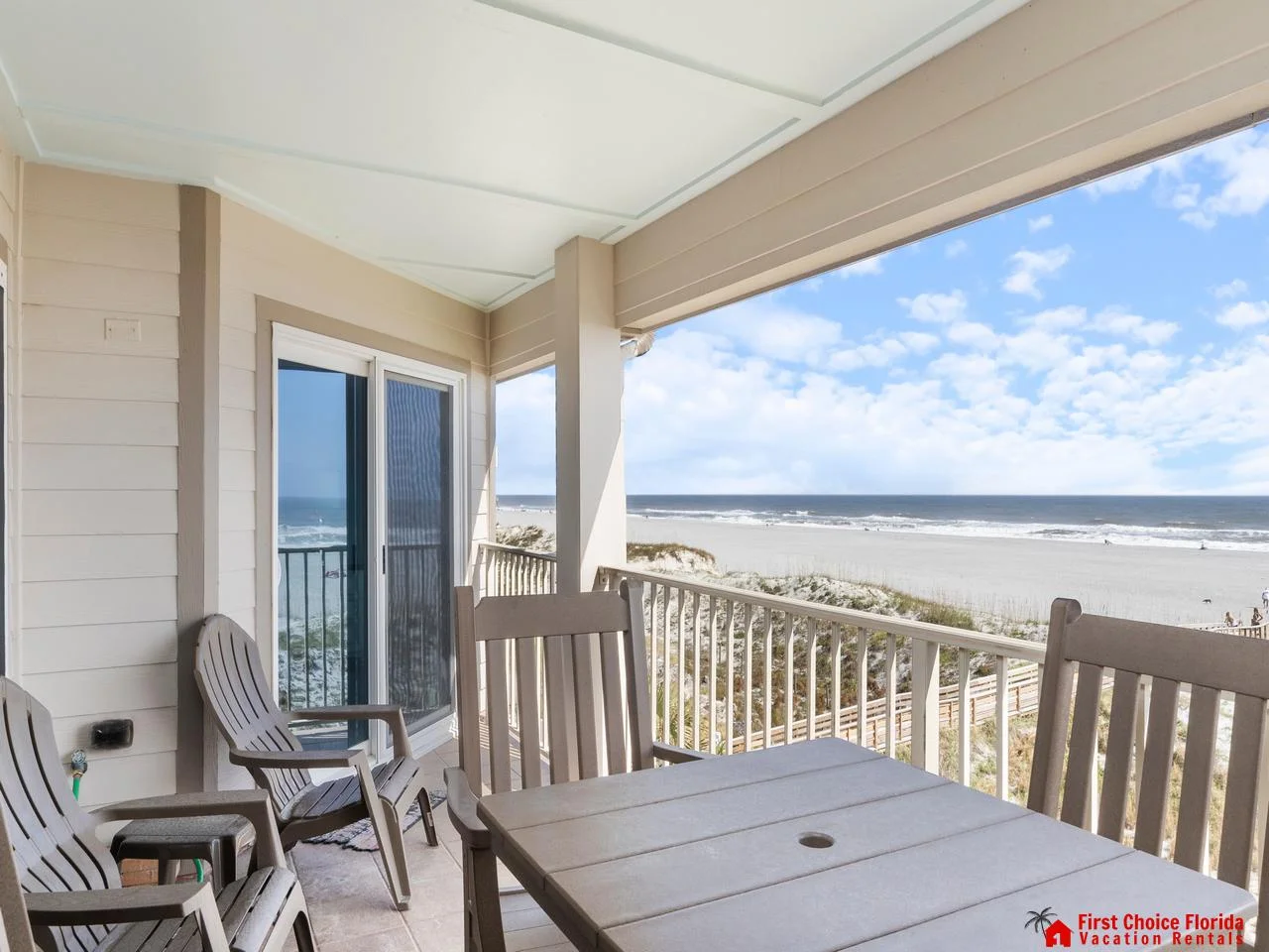 Oceanfront balcony with panoramic beach views and cozy seating