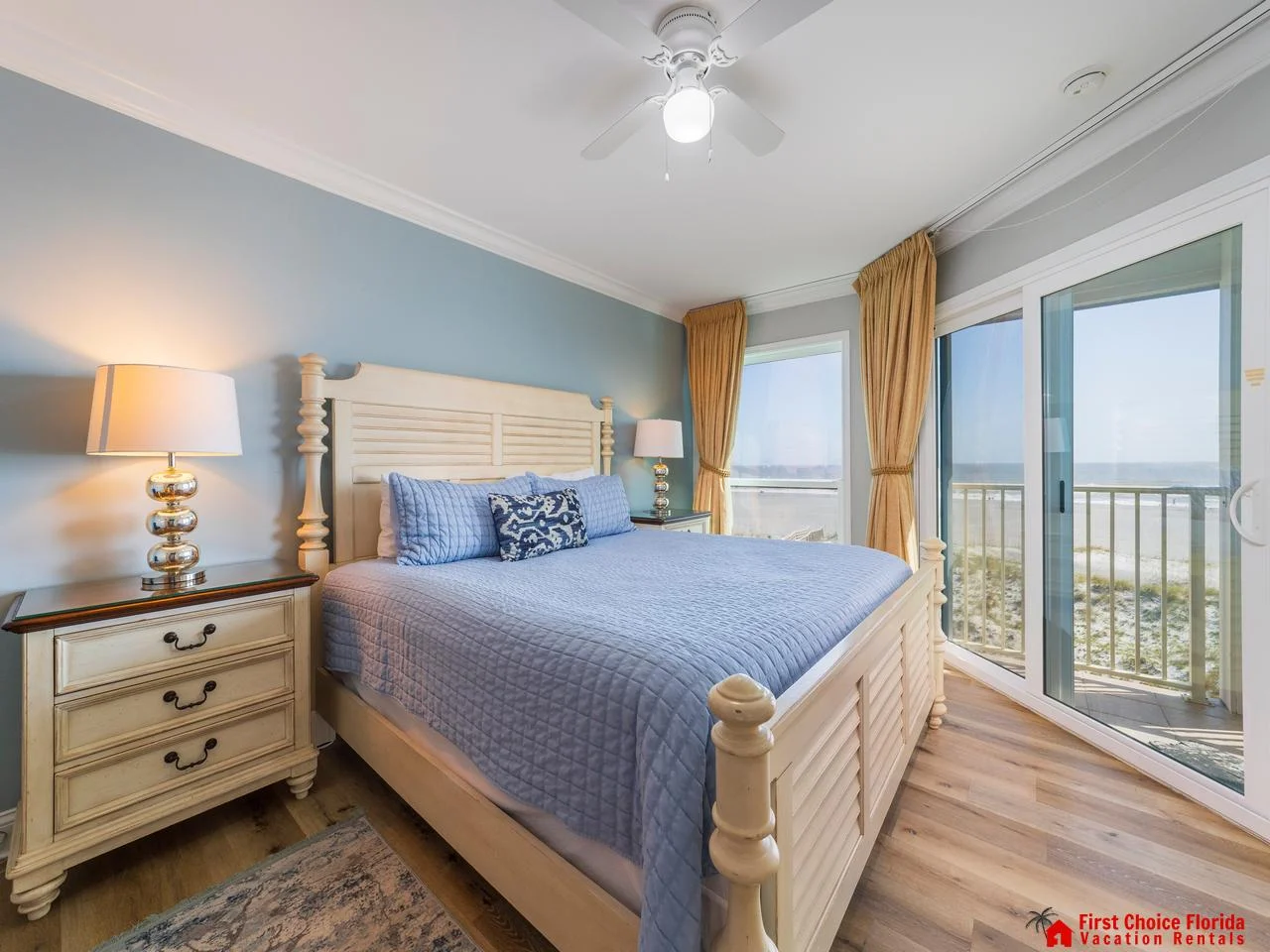 Sunlit primary bedroom with balcony views and king bed
