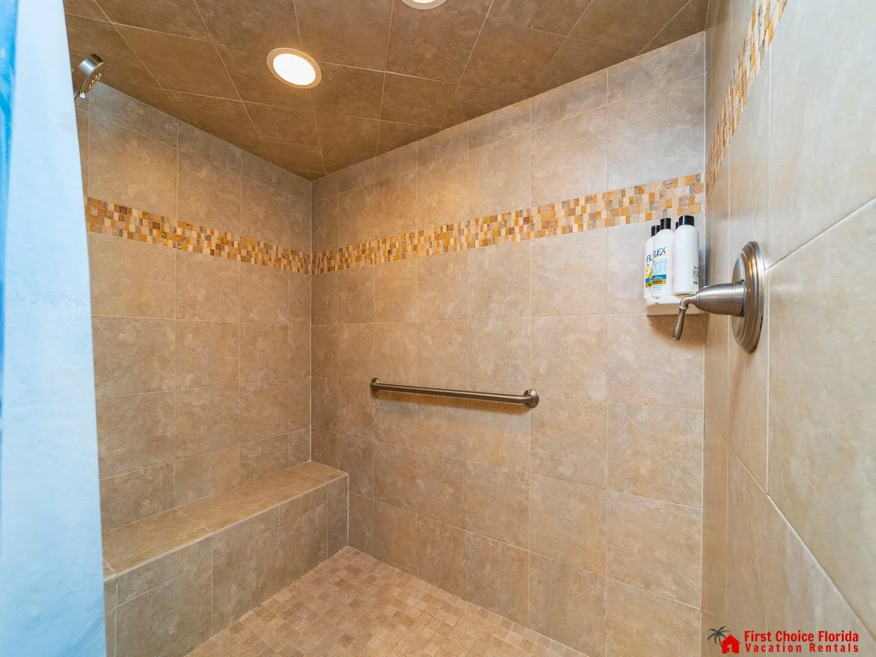 Spacious tiled primary shower with built-in bench for ultimate comfort
