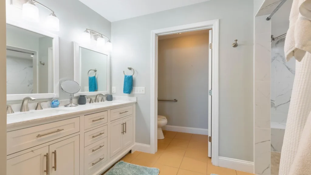 The primary bathroom features a double vanity with a marble countertop, brushed nickel fixtures, and soft blue-gray walls.