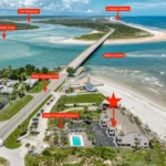 Cluster of beige beachfront condos with rooftop decks and direct stair access to the white sandy beach.