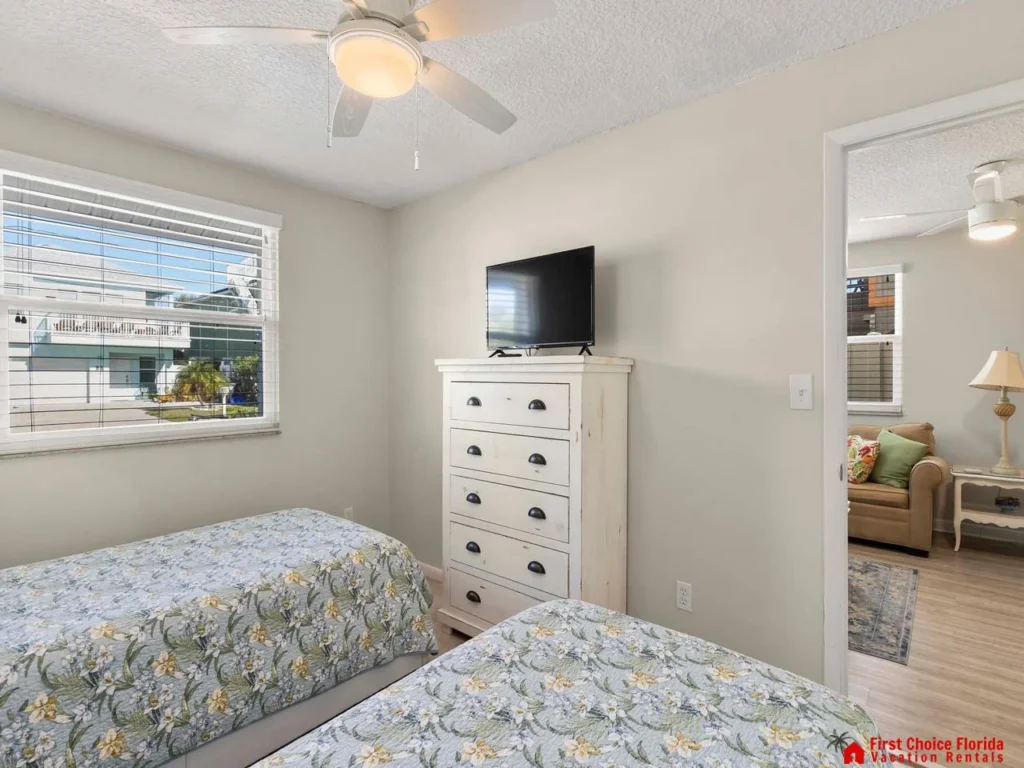 Cozy twin bedroom with bright window and smart TV