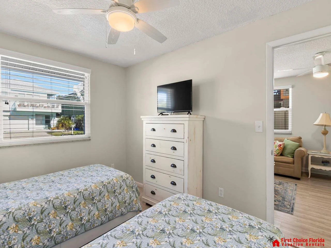Cozy twin bedroom with bright window and smart TV