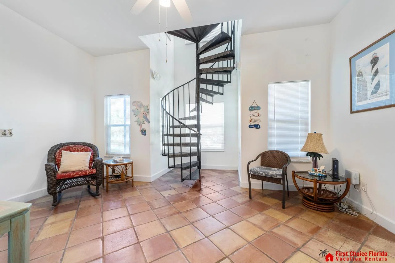 Bright first floor entry with charming spiral staircase and cozy seating!