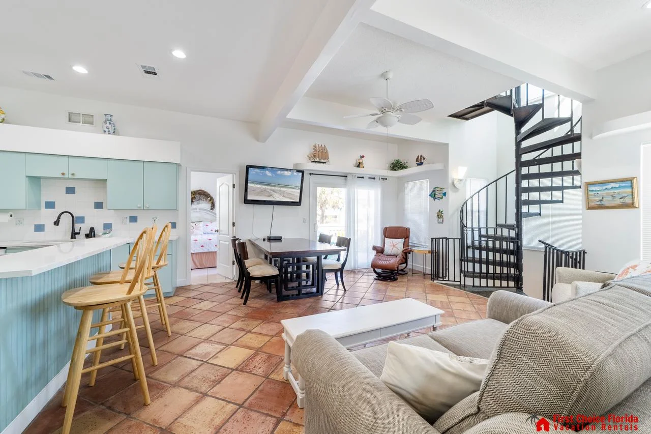 Bright open living area with cozy seating and spiral staircase!