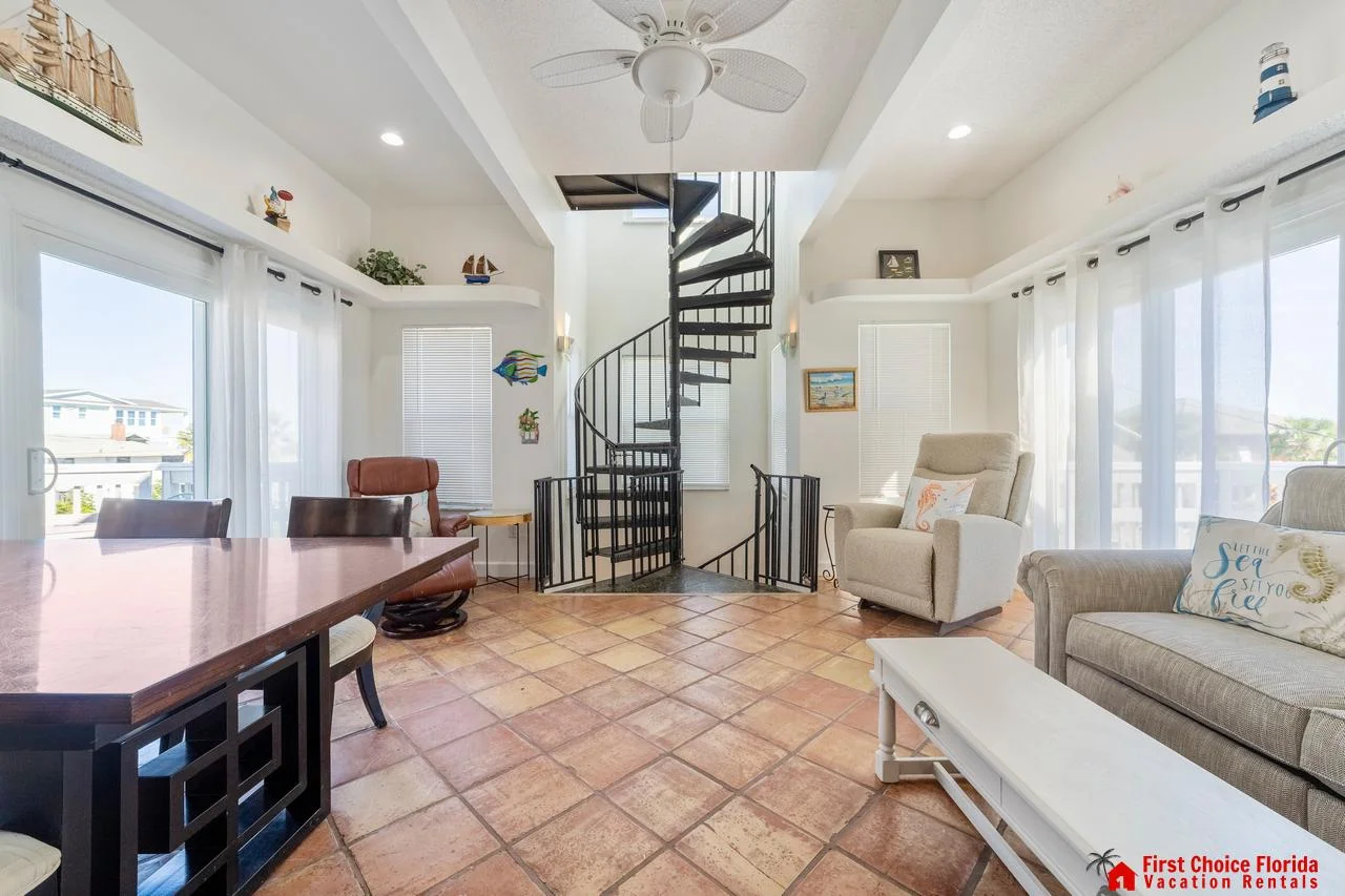 Bright, airy living room with spiral staircase to third floor bedroom!