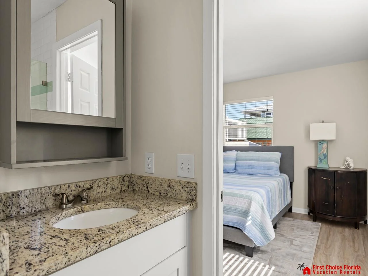 Bright bedroom with cozy bed and granite bathroom vanity