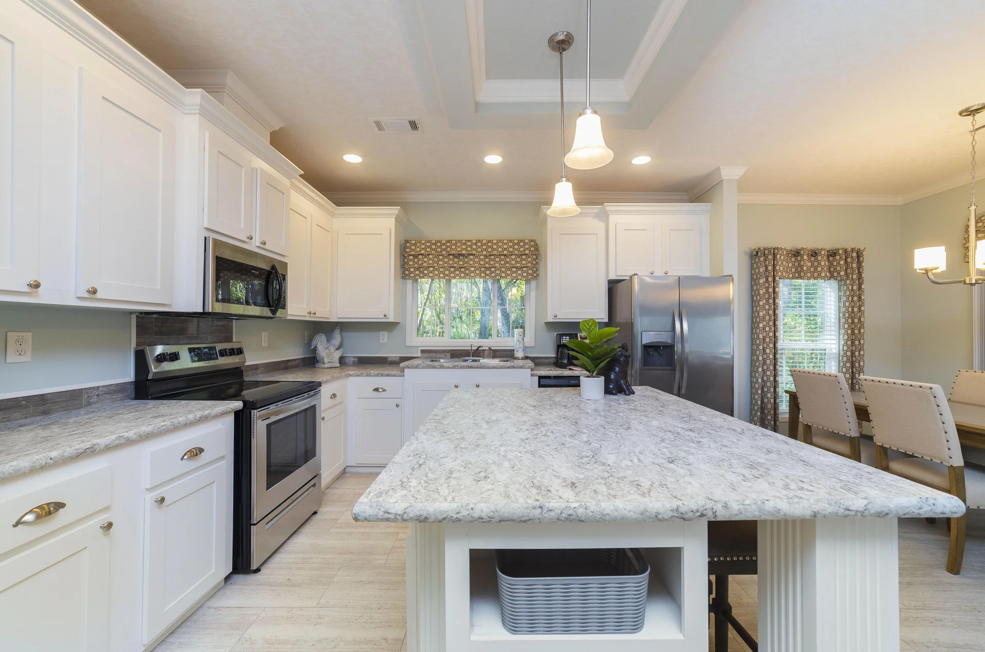 Marble-patterned kitchen island with open shelving beneath, illuminated by two pendant lights.