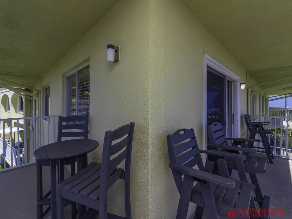 Two dark wooden seating areas with armchairs and small tables flank the wrap-around balcony’s corner wall.