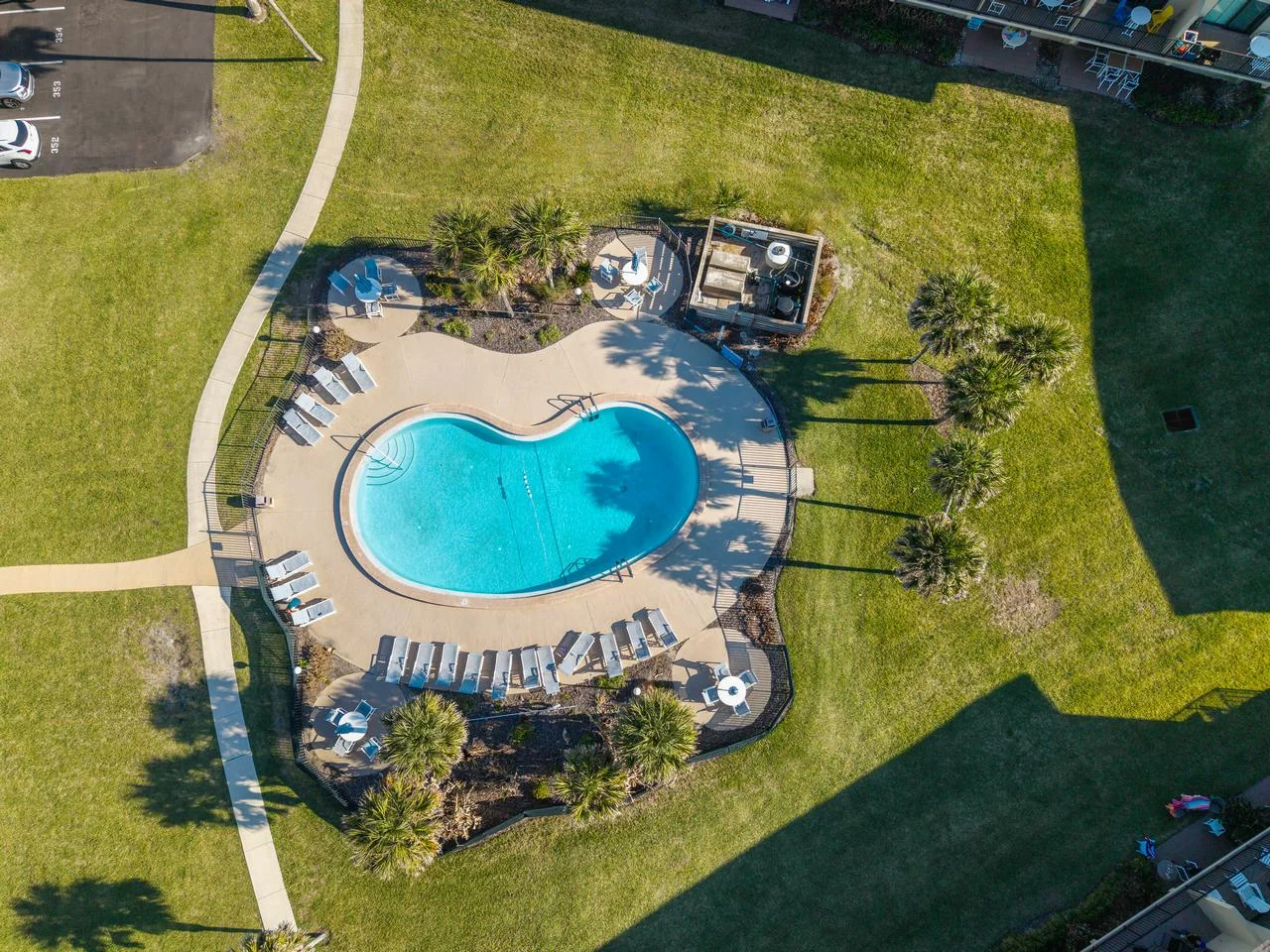 Resort-style pool with ample lounge seating and lush greenery
